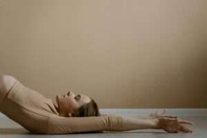 Woman in Beige Long Sleeve Shirt Lying on Bed